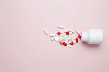 White bottle container with colorful medication capsules and tablets. Concept of healthcare and medicine