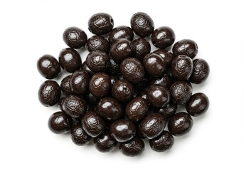 A heap of shiny dark brown olives clustered together on a plain white surface in a close up shot