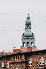Obraz premium Old brick tenement houses in a workers' housing estate. Church tower in the background. Katowice, Nikiszowiec. Poland