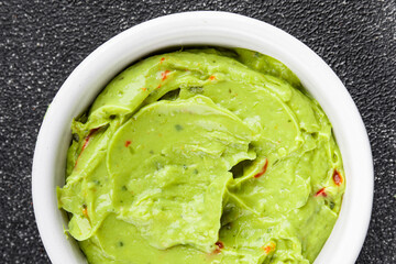 Guacamole dip avocado sauce cold appetizer vegetable dish organic product fresh tasty gourmet food background on the table rustic food top view copy space 