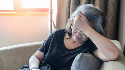 Menopause woman with anxiety disorder, mental health illness, stressful depressed aging female person with headache and migraine pain sitting tiredly at home