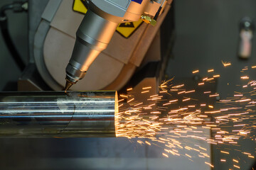 Close up scene the multi axis fiber laser cutting machine cut the stainless steel tube with...