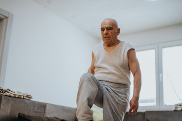 Fototapeta premium An elderly man engaging in physical exercises inside a bright living room, showcasing determination and commitment to a healthy lifestyle.