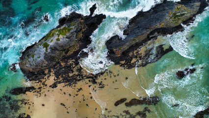 Rocks off the coast in rough seas, seen from above