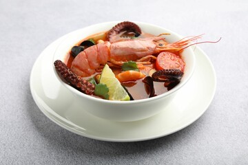 Tasty seafood soup in bowl on light grey table, closeup