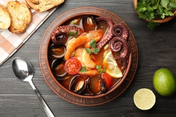 Tasty seafood soup served on wooden table, flat lay
