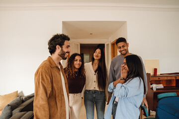 A multinational group of young people is smiling and laughing together during a birthday party,...