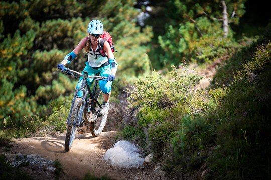 Woman mountain biking on a forest trail near Swiss Alps, Davos, Graubunden, Switzerland