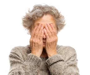 A mature woman covers her face with her hands, expressing feelings like sadness, grief, despair, or shame. The image conveys intense emotion.