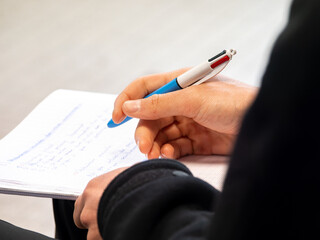 Gros plan sur des mains prenant des notes lors d’une formation PSC1, stylo en main sur feuille de papier