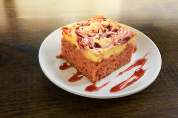 Square shape strawberry cheese cake on white dish.
