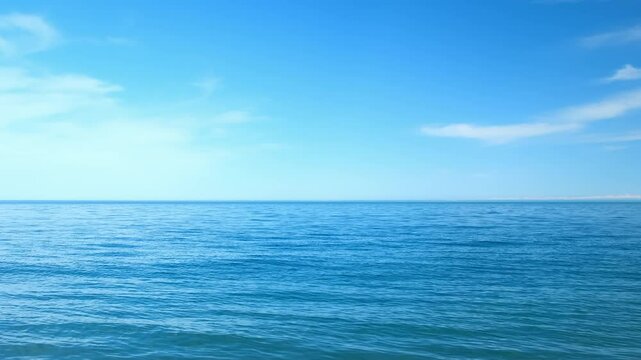 Nature blue background with wavy sea ripples on water surface and cloudy sunny sky. Scenery seascape horizon light. Wild ocean coastline, tourism, place for rest relax on vacation, journey, trip.