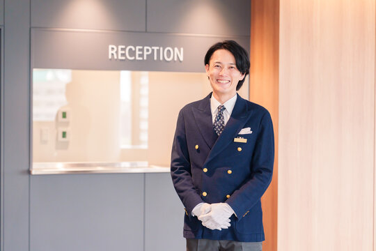 笑顔で接客をするホテルマンの男性