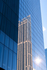 Fototapeta premium tall building is reflected in the windows of another building
