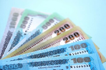Bangladeshi taka money bills in big amount lies on teal color table close up