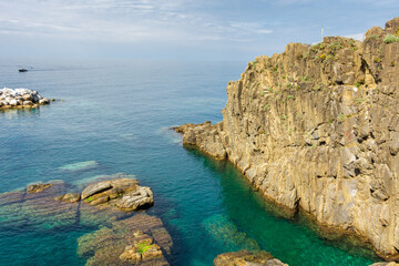 Obraz premium Crystal clear water on the coastline of Riomaggiore, Cinque Terre, Liguria, Italy