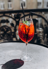Refreshing Red Cocktail with Mint Leaves on a Sunny Balcony