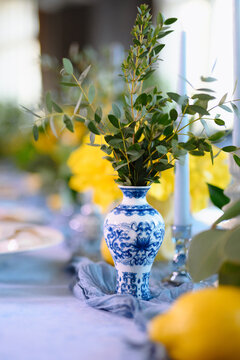 Elegant Table Decor with Blue and White Vase Featuring Lush Greenery
