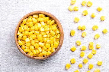Canned vegetable maize, whole sweet corn kernels in a wooden bowl on linen. Variety of corn that is...