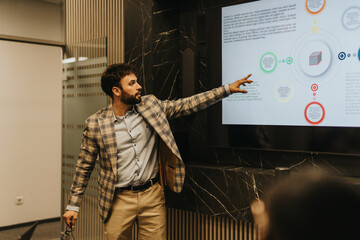 A business person presents late at night with a digital screen, using visuals to explain data. The...
