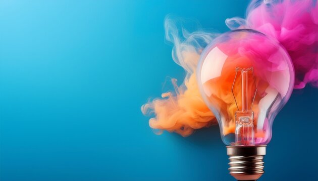 vintage light bulb generating colorful orange and pink smoke on blue background concept of creative idea copy space for text