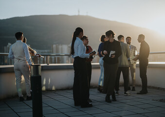 A diverse group of business colleagues engage in a brainstorming session on a rooftop at sunset. The multiracial team collaborates amidst an inspiring cityscape, fostering creativity and innovation.