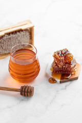 honey in a glass jar and honeycombs
