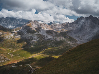Alpine valley and rugged peaks under dramatic sky