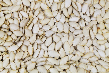 Many raw pumpkin seeds as background