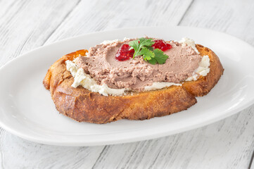 Gourmet sandwich layered with pate, cranberry jam, and cream cheese