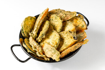 Fried vegetables such as courgettes and aubergines in a black basket, isolated on a white background. Minimalist style, golden and green tones, simple composition, traditional Italian dish.