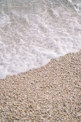 Sea surf rolls onto the pebble beach