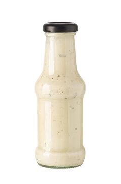 Glass sauce bottle filled with creamy salad dressing on transparent background