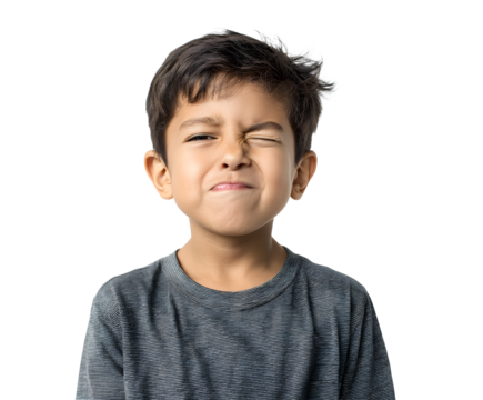 A young boy with dark hair squints, creasing his face in a playful grimace against a black background, capturing a moment of childlike expression.
