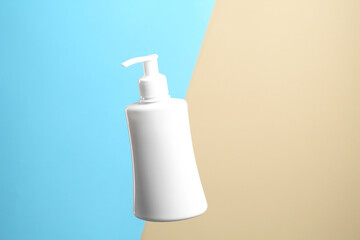 Cosmetic product in bottle on color background