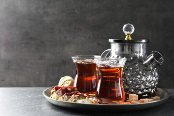 Tasty Turkish tea and delight on black table. Space for text