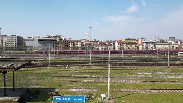 Europe,Italy, Milan 04,27,2025 drone view of Centrale train station railway with skyline in downtown - travel with Frecciarossa and Italo high speed trains to Bologna, Florence, Rome and Naples 