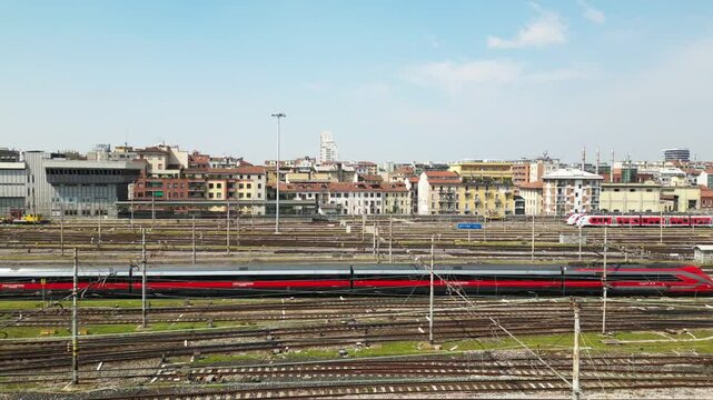 Europe,Italy, Milan 04,27,2025 drone view of Centrale train station railway with skyline in downtown - travel with Frecciarossa and Italo high speed trains to Bologna, Florence, Rome and Naples 