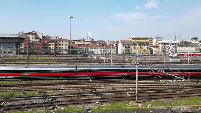 Europe,Italy, Milan 04,27,2025 drone view of Centrale train station railway with skyline in downtown - travel with Frecciarossa and Italo high speed trains to Bologna, Florence, Rome and Naples 