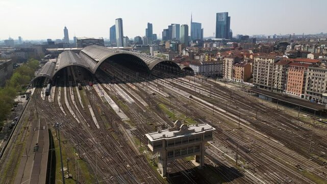 Europe,Italy, Milan 04,27,2025 drone view of Centrale train station railway with skyline in downtown - travel with Frecciarossa and Italo high speed trains to Bologna, Florence, Rome and Naples 