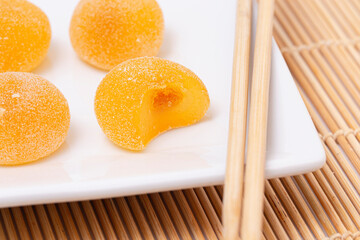 Sweet Mango Flavored Fruit Mochi on a Bamboo Mat with Chopsticks