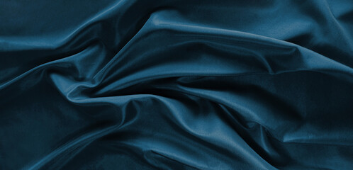 Close-up of dark teal silk with soft folds. Smooth and luxurious surface with rich color. Luxury elegant backgrand for design