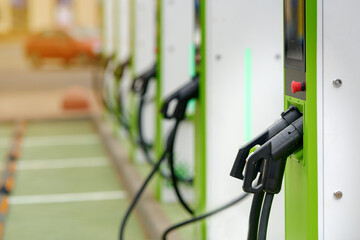 Close-up of charging station connector plug. Car charging station, plug and connector details in an urban environment. Electric car charger.