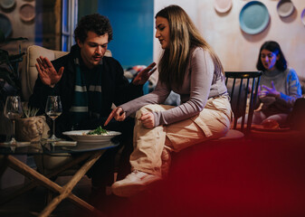 Group of friends sharing food and laughter in a warm, relaxed lounge bar environment.