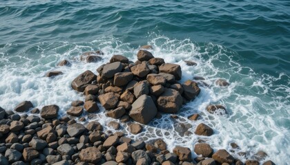 Fototapeta premium Scenic View of Rocky Shoreline with Waves Crashing Against Stones in Clear Blue Water