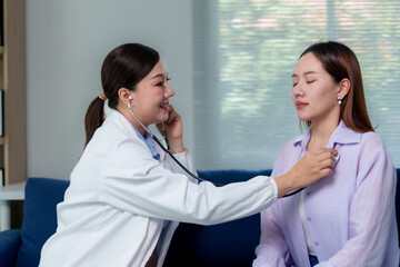 Female doctor examining patients heartbeat with stethoscope in a clinic, providing professional...