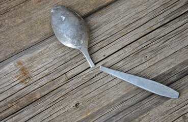 old broken spoon on a wooden table. top view