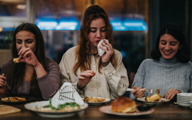Group of friends happily dining together in a cozy restaurant setting with delicious food.