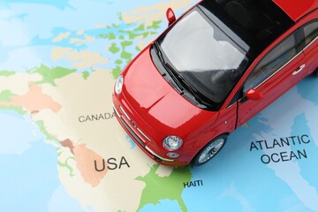 Road trip concept. Car model on world map, closeup