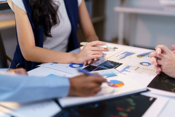 Business people working together discussing financial charts and graphs showing company results